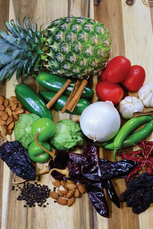 Piña, chiles secos, ajo y cebolla sobre tabla de madera